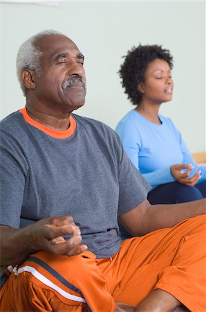two adults practicing their yoga meditation
